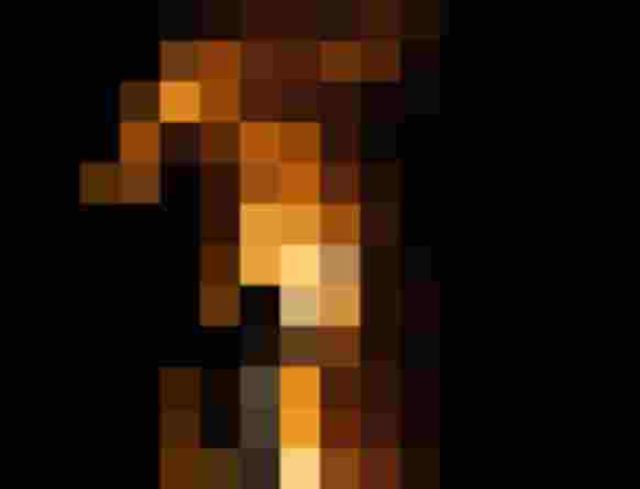 Person steht vor großem Lagerfeuer Funken fliegen in die dunkle Nacht