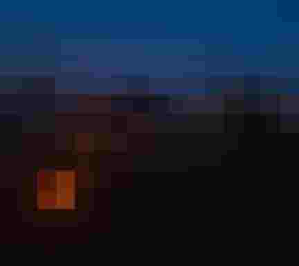 Bergfeuer und Lichterkette bei Nacht in den Alpen mit Sternenhimmel