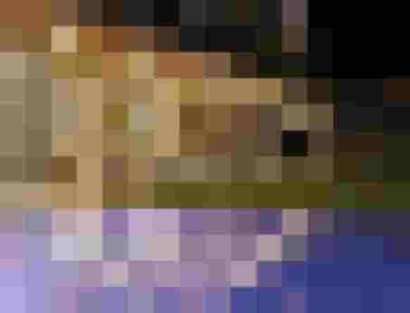 Beleuchteter Infinity Pool mit Liegestühlen vor Glasfassade im Wellnesshotel Salzburger Land